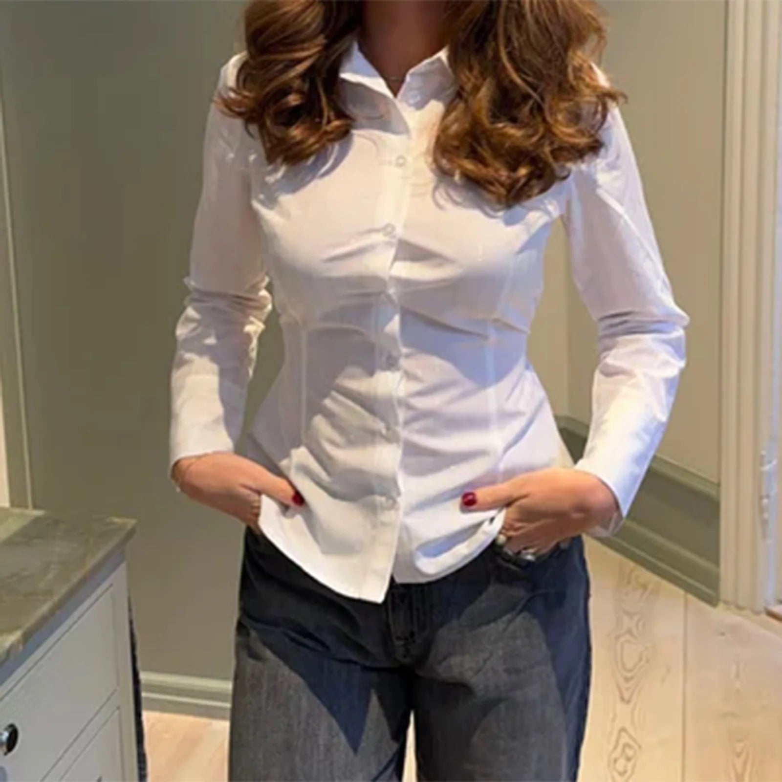 Person wearing a white shirt and dark pants in an indoor setting