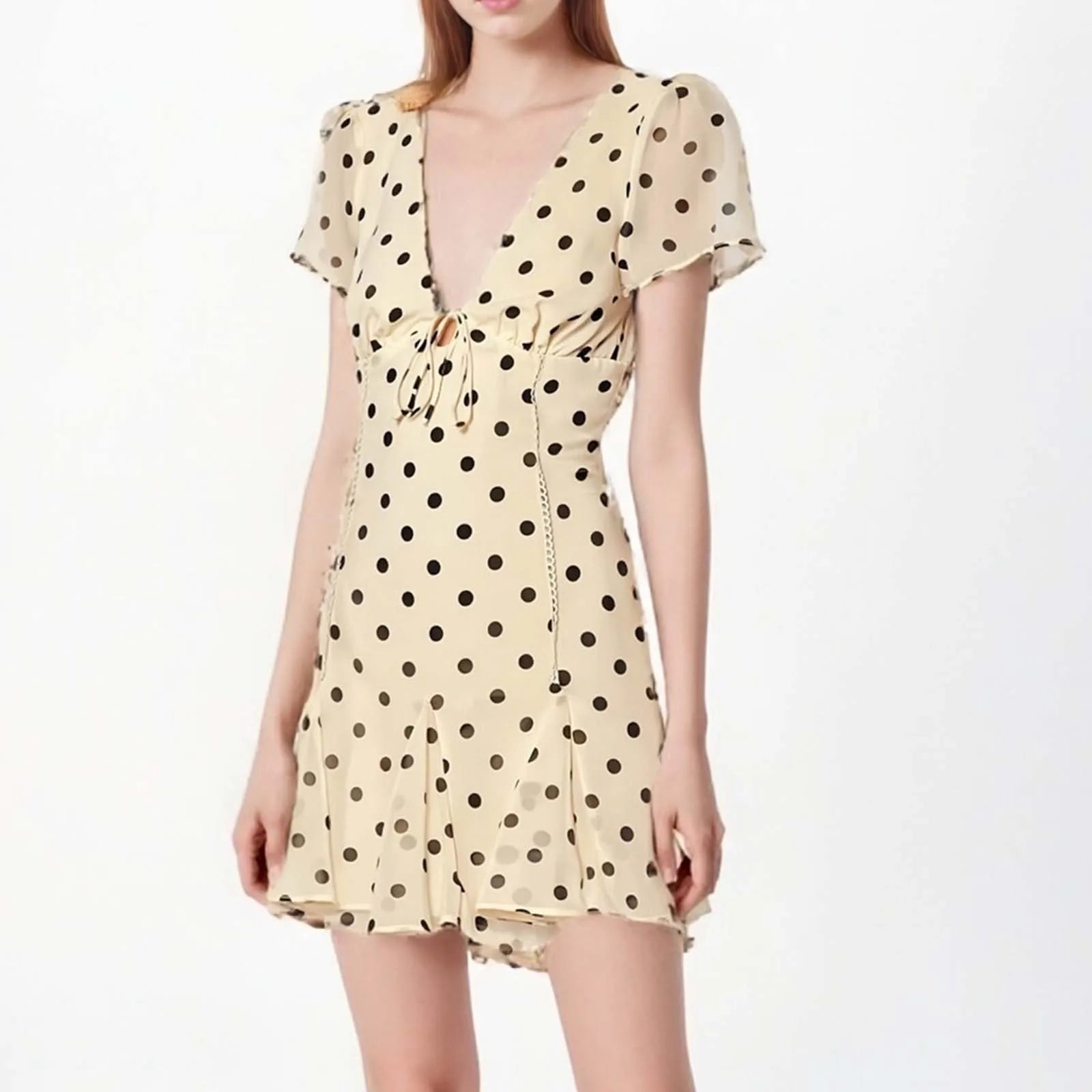Beige dress with black polka dots on a white background