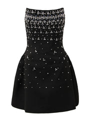 Black strapless dress with silver embellishments on a white background