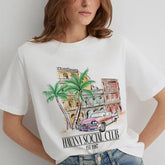 Person wearing a white t-shirt with a colorful graphic design of a cityscape and palm trees, labeled 'Havana Social Club'.