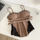 Brown lace lingerie set on a white surface with a laptop and glass in the background
