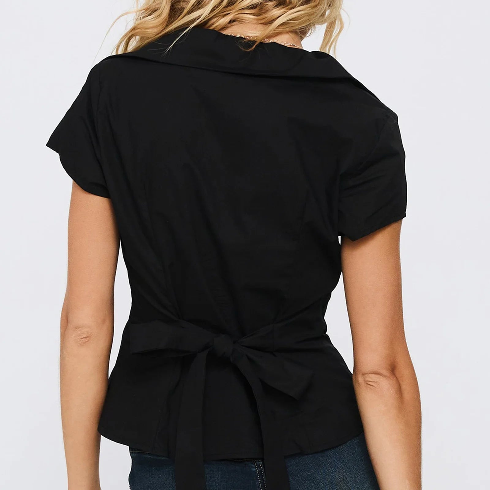 Black short-sleeve blouse with a tie waist worn by a person - back