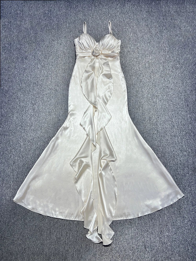 White satin dress with floral details on a textured gray background