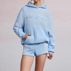 Light blue hoodie and shorts set with embroidered design on a plain background