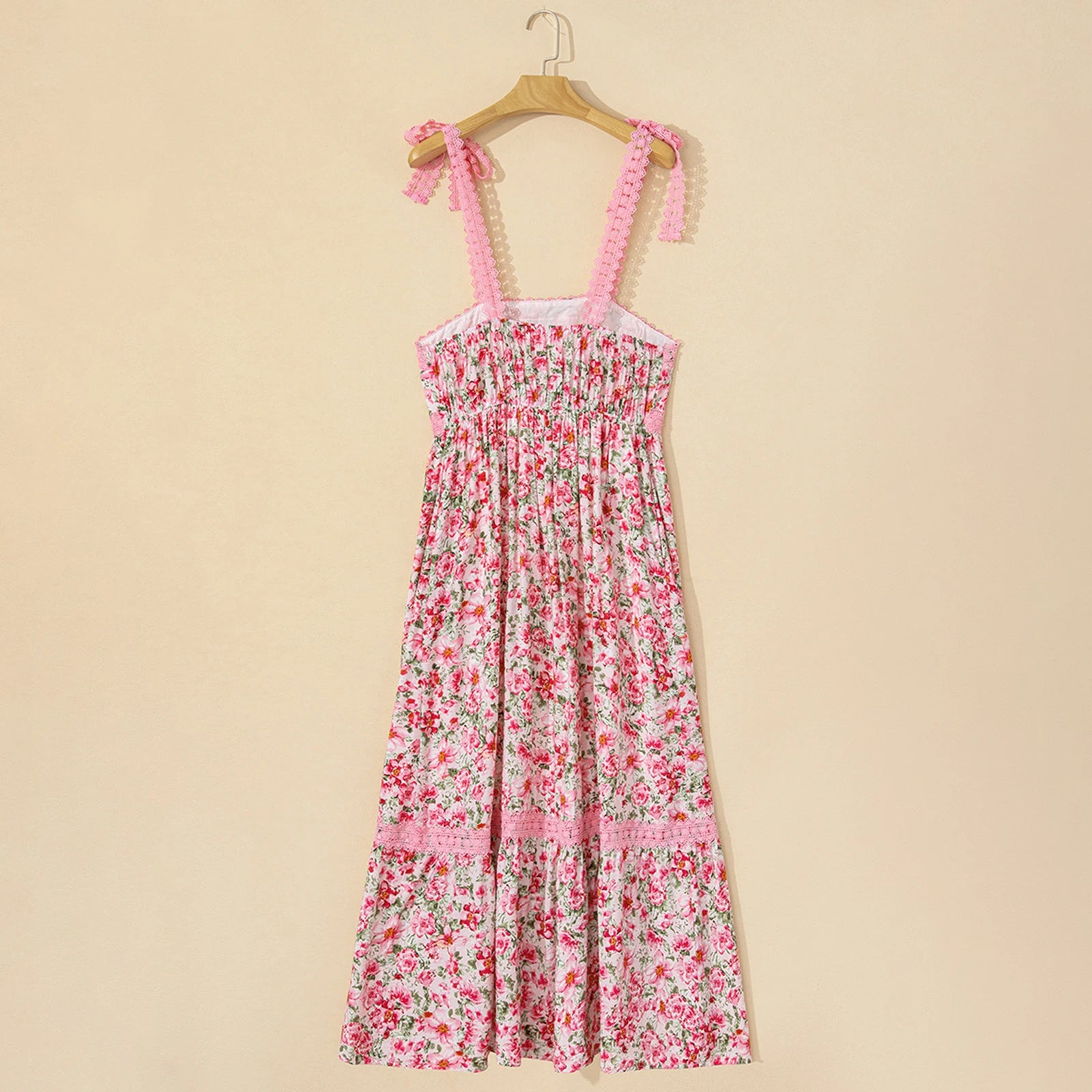 Floral dress with pink straps on a wooden hanger