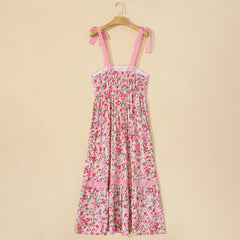 Floral dress with pink straps on a wooden hanger