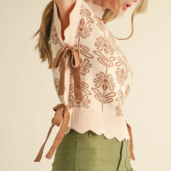 Woman wearing a patterned sweater with a tie detail on a beige background