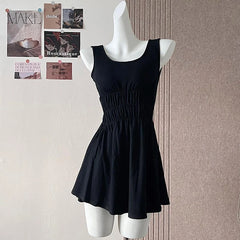 Black dress on a mannequin against a wall with magazines.