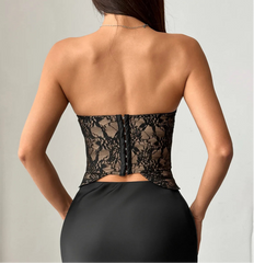 Black lace corset worn by a model on a plain background
