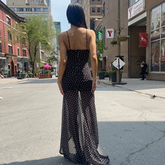 Woman in a black polka dot dress standing on a city street