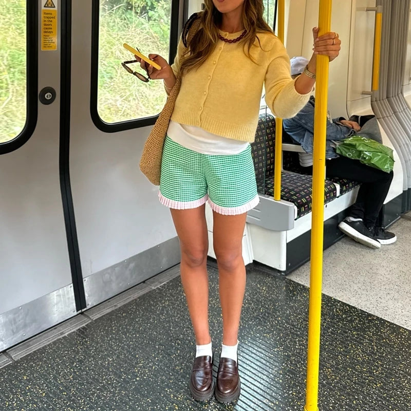 Women's charming green plaid shorts with ruffled hem.