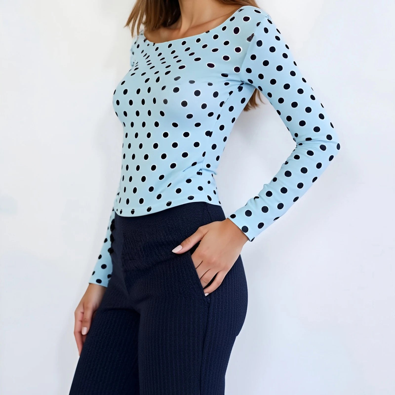 Light blue long-sleeve top with black polka dots worn by a model