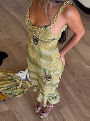Woman wearing a green floral dress on a wooden floor