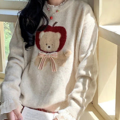 Person wearing a sweater with a teddy bear design in a bright indoor setting