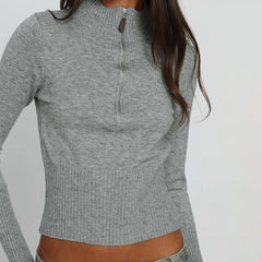 Gray long-sleeve top worn by a person on a plain background