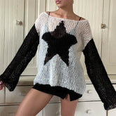 Person wearing a black and white sweater with a star design in a room.
