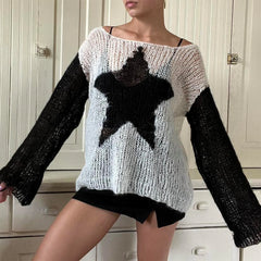 Person wearing a black and white sweater with a star design in a room.