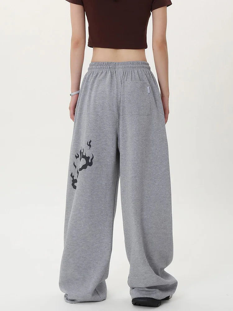 Person wearing gray sweatpants with a black design