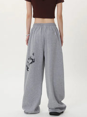 Person wearing gray sweatpants with a black design