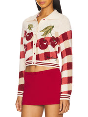 Woman wearing a red and white cardigan with cherry design
