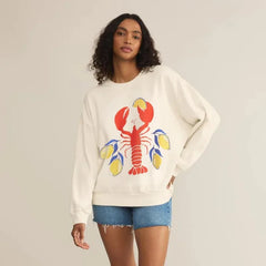 Woman wearing a white sweatshirt with a colorful lobster design