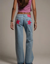 Person wearing light blue jeans with red star