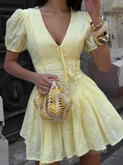 Women's yellow tie-up puff sleeve mini dress with a V-neck and A-line silhouette.