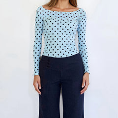 Light blue long-sleeve top with black polka dots worn by a model