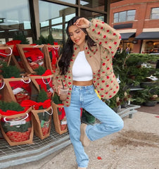 Woman posing in front of Christmas tree bags at a store