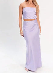 Woman wearing a light purple two-piece outfit on a white background