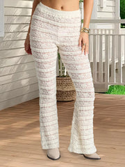 Person wearing white textured pants on a wooden deck.