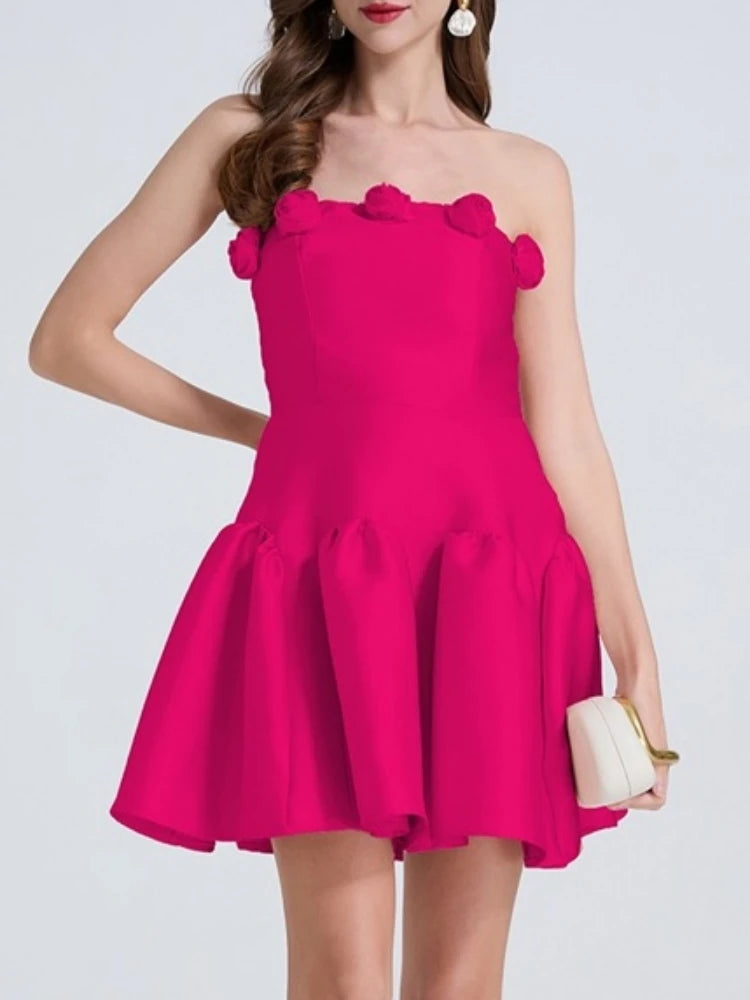 Woman wearing a bright pink dress with ruffled shoulders on a white background