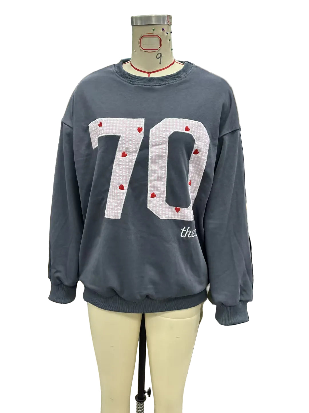 Gray sweatshirt with '70' print on a mannequin in a store setting