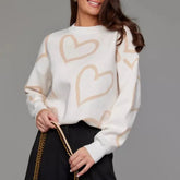 Woman wearing a white sweater with beige heart patterns