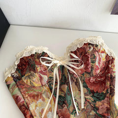 Floral patterned garment with lace details and a bow