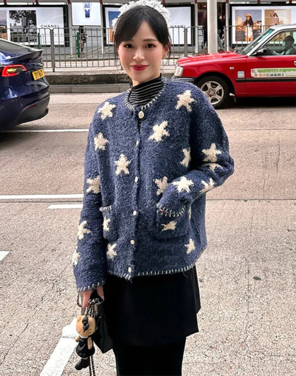Woman wearing a blue floral cardigan on a street with cars