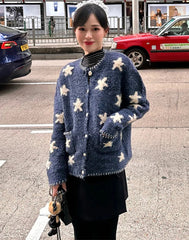 Woman wearing a blue floral cardigan on a street with cars