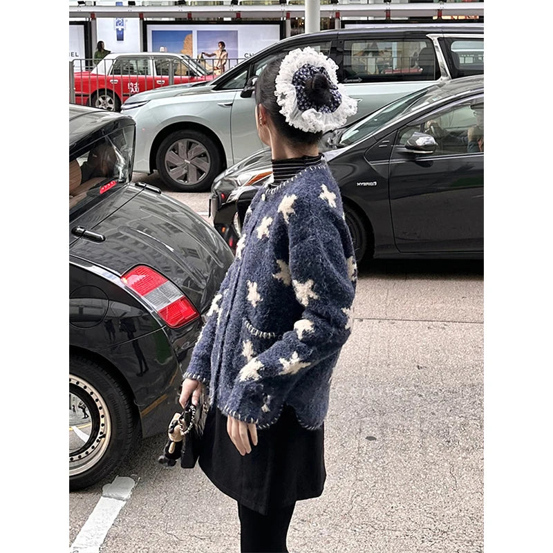 Person wearing a blue sweater with white patterns in a parking lot.