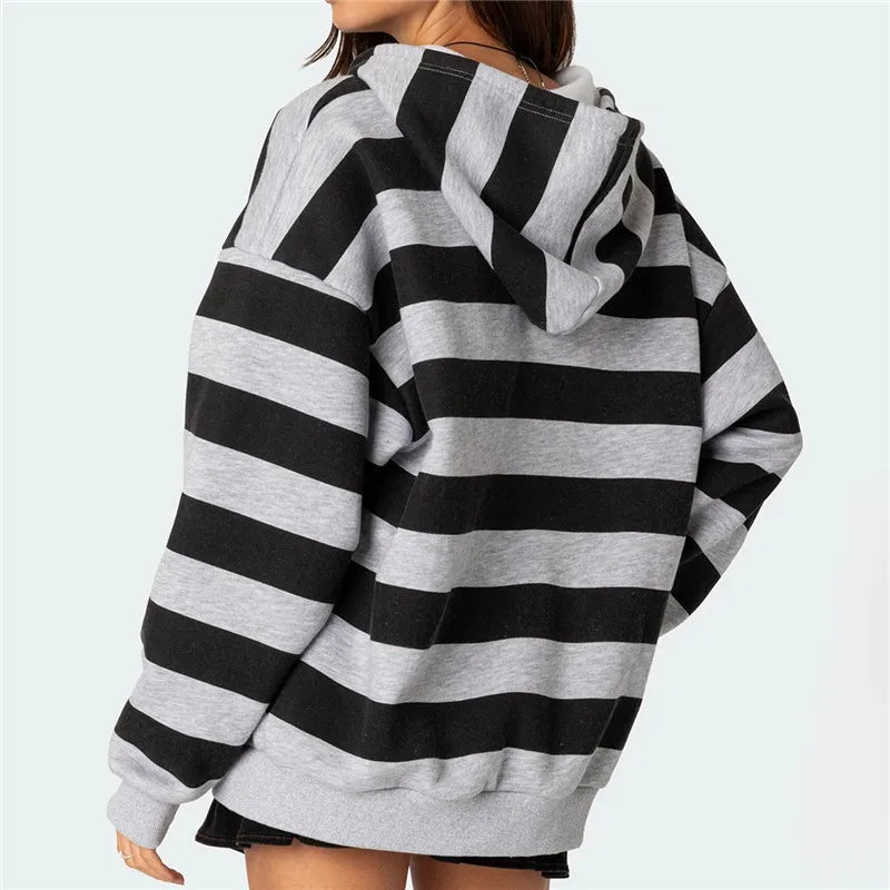 Black and gray striped hoodie worn by a person on a light blue background