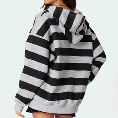 Black and gray striped hoodie worn by a person on a light blue background