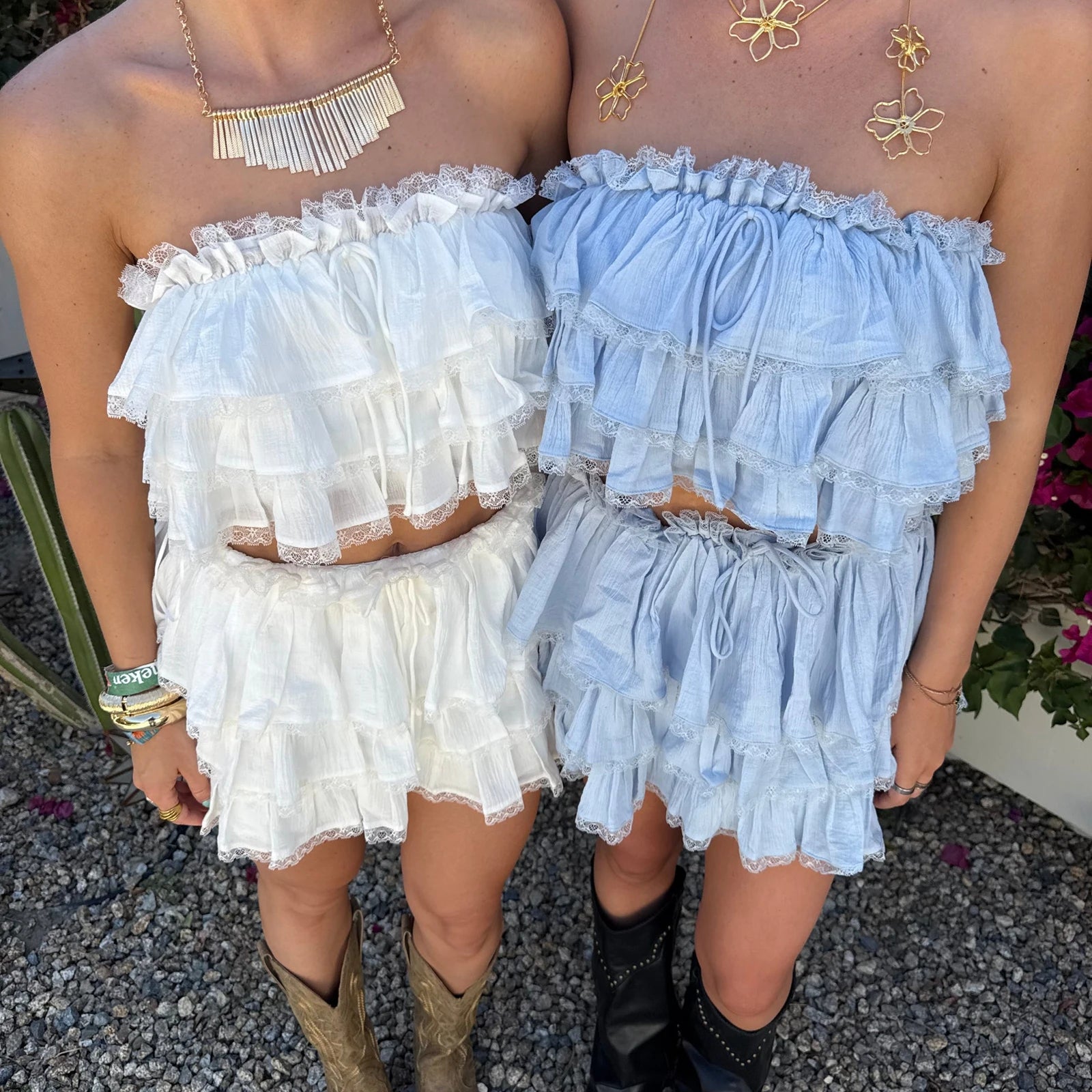 Two people wearing off-shoulder ruffled dresses in white and light blue.