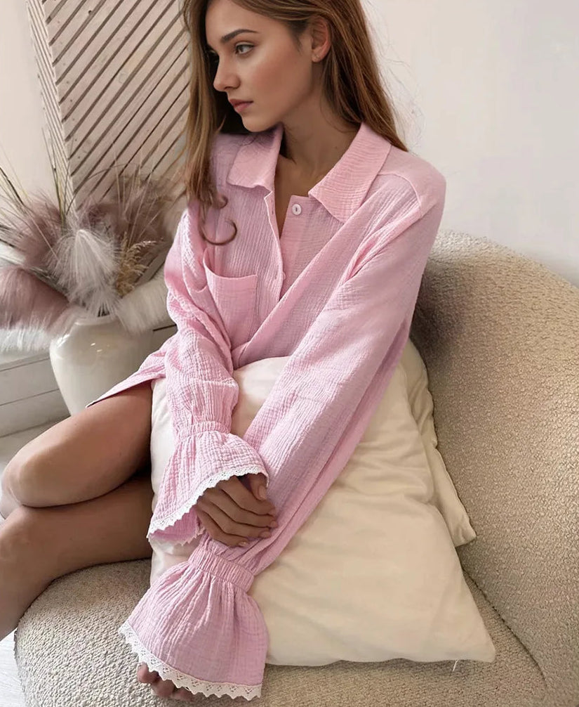 Woman wearing a pink textured shirt sitting on a couch.