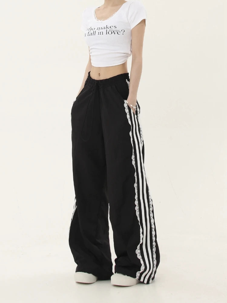 Person wearing a white crop top and black pants with white stripes