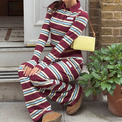 Person wearing a maroon and blue striped outfit sitting on steps with a yellow bag.
