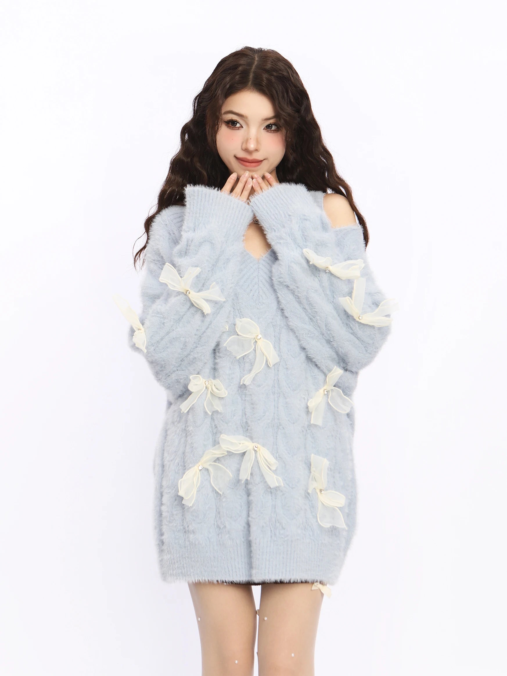 Light blue sweater with white bow details worn by a model