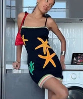 Woman in a dress with starfish designs standing in a kitchen.