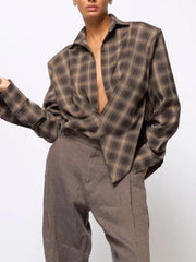 Person wearing a plaid shirt and gray pants