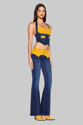 Woman wearing a denim and yellow outfit on a white background