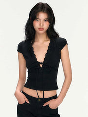 Woman wearing a black top with ruffled details