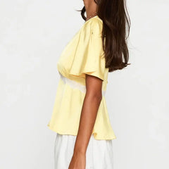 Model displaying a short lace trim flare short sleeve top with a V-neck.
